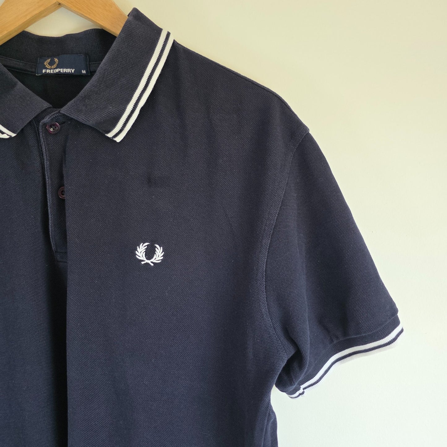 Fred Perry navy blue polo shirt with twin tipped collar and cotton material.