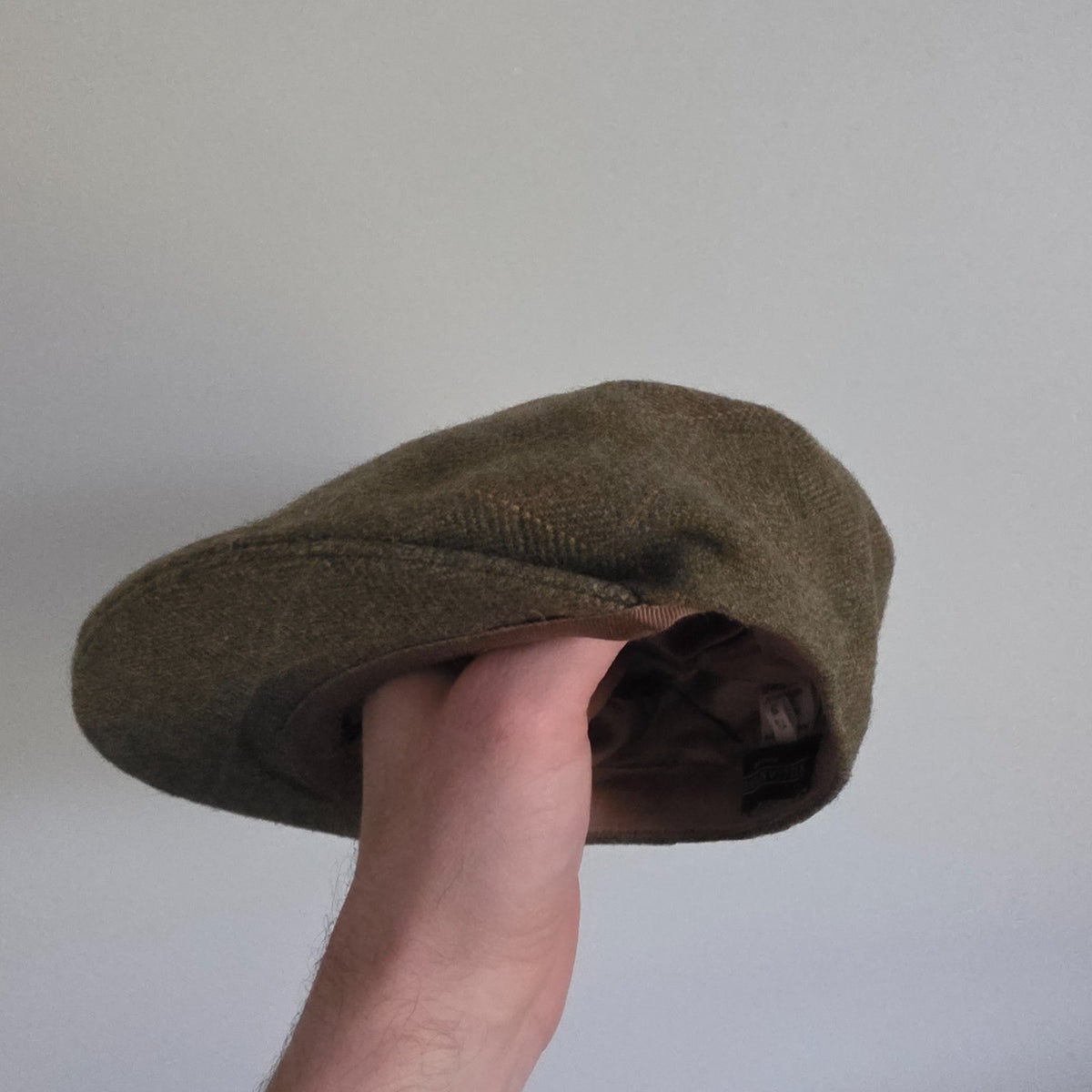 William Powell brown tweed flat cap with stitched panel construction and subtle flecks.