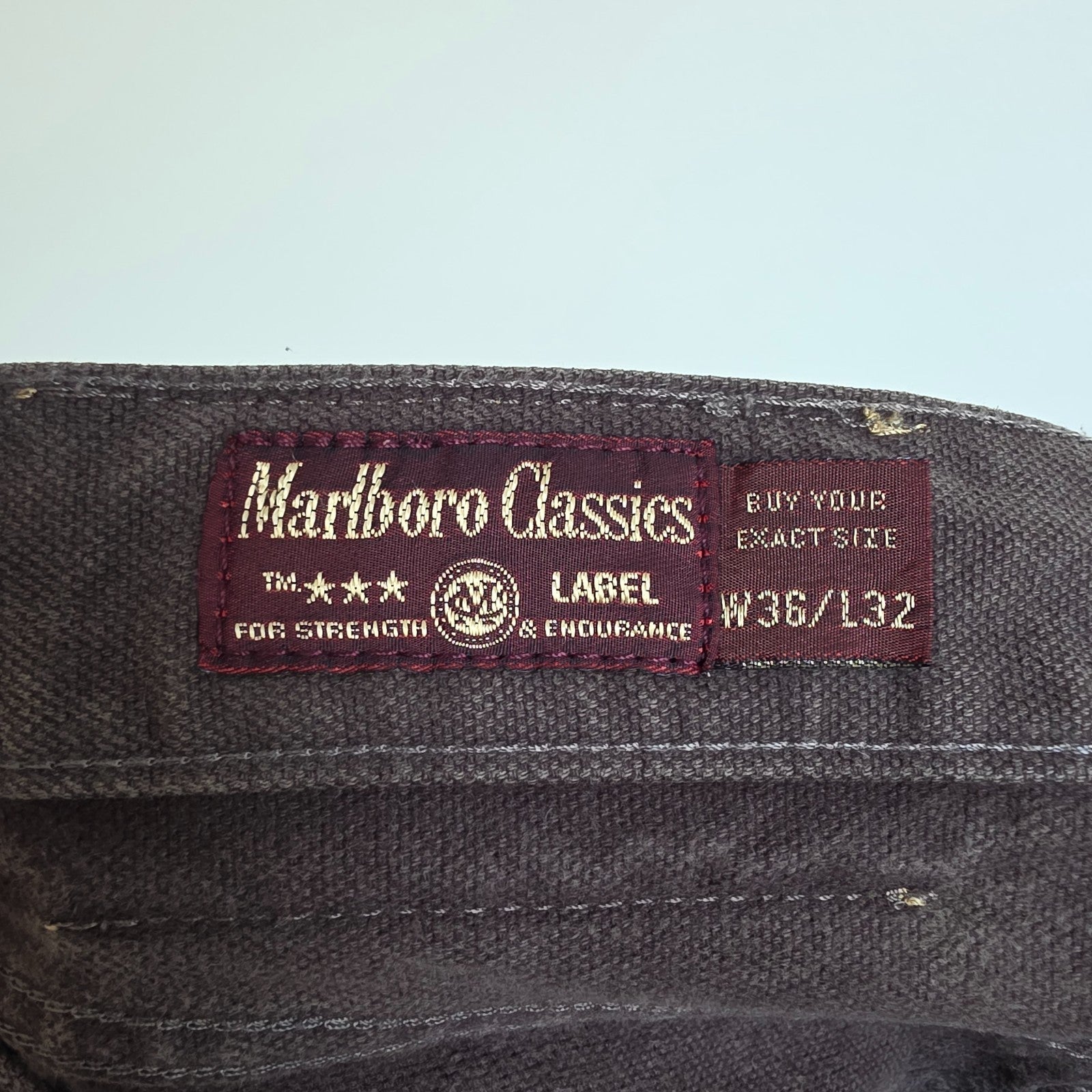Marlboro Classics grey straight jeans with button fly and vintage logo detail.
